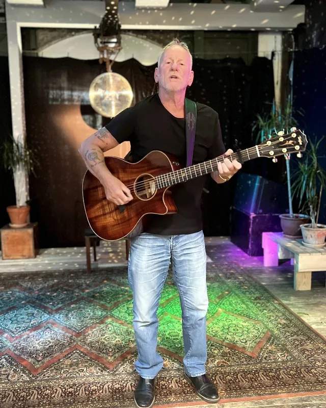 Lars Bo Bendixen i helfigur med guitar, synger mod kameraet